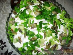 Салат "Купальская ночь": Выложить редис, порезанный тонкими кружочками. Промазать заправкой.  Посыпать салат из свежих овощей зеленым луком, порезанным кольцами и семенами тыквы.
