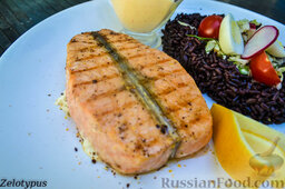 Стейк из лосося, с черным рисом: Готовый стейк из лосося с рисом и соусом.
