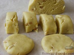 Медовое печенье с арахисом: Разделить тесто на 2 части. Из каждой части скатать валик, разделить его на небольшие кусочки.  Кусочкам придать форму лепёшек.