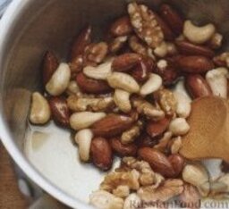 Полезный завтрак из орехов, йогурта и черники: 2. Выложить в него орехи и хорошо перемешать. Снять сотейник с плиты, дать орешкам слегка остыть.