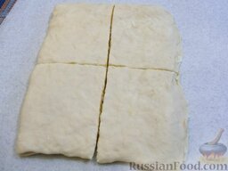 Слойки с сыром (из замороженного теста): Прикройте второй половиной, прокатайте сверху скалкой и разрежьте на 4 равные части.