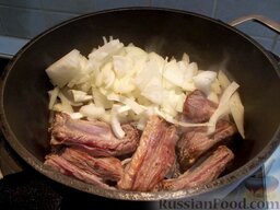 Тушеные свиные ребрышки: Когда мясо подрумянится, добавьте к нему лук.