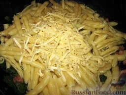 Запеканка из макарон, грудинки и шпината: Добавить в сковороду макароны, базилик  и половину тертого сыра. Все перемешать.