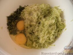 Закусочные оладьи кабачковые: Добавить в миску тертые кабачки, зелень, яйца, соль, разрыхлитель для теста (по желанию).