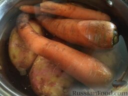 Винегрет с кальмарами и луком-пореем: Помыть морковь и картофель. Сложить в казанок, залить холодной водой. Поставить на огонь, довести до кипения. Варить на среднем огне до готовности (около 20 минут). Воду слить. Овощи охладить.