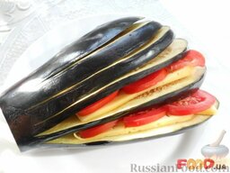 Баклажаны, фаршированные помидорами и сыром: Часть твердого сыра нарезать пластинками, а 2 помидора помыть, обсушить и нарезать кружочками. Между полосками баклажанов положить по 2-3 кружочка помидора и по 2 ломтика сыра.