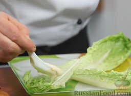 Салат Цезарь в стиле фьюжн: Собираем салат «Цезарь». Выкладываем на плоскую тарелку листья салата. Промазываем их соусом.