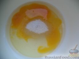 Оладьи молочные: Яйца вбить в миску, добавить соль и сахар.