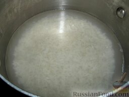 Голубцы с мясом и рисом: Рис промойте, выложите в кастрюлю, налейте воду (в 1,5 раза больше, чем риса), посолите и варите до полуготовности.