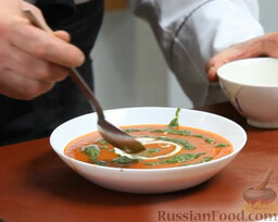 Томатный суп с песто: Песто из базилика выкладываем спиралью, оставшуюся сметану – тоже спиралью, в противоположном направлении.