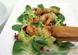 Салат с жареными креветками: На сервировочную тарелку выложить листья салата. Сверху выложить креветки.