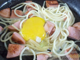 Спагетти с колбасой, яйцом и зеленью: Вбейте аккуратно яичко, чтобы желток остался целым. Приправьте солью.