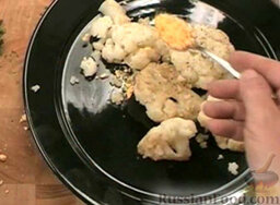Цветная капуста по-польски: Капусту на тарелке посыпать измелченным желтком и петрушкой.  На сковороде растопить оставшееся масло. Высыпать в сковороду сухари и обжарить их, помешивая.