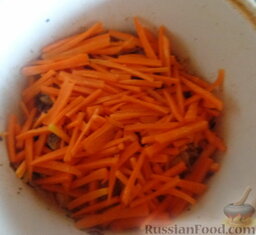 Плов с курицей: Добавляем морковь и ни в коем случае не перемешиваем.  Накрываем крышкой и тушим минут 5.