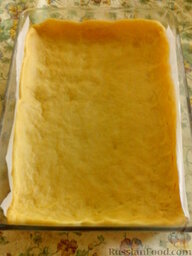 Яблочный пирог в сметанной заливке: Форму для запекания (у меня 35х25 см) застелить бумагой для выпечки или смазать маслом. Выложить 2/3 теста и руками распределить по всей форме, сделав небольшие бортики.