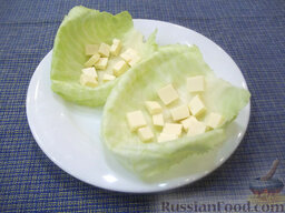 Легкий салат с соленой горбушей: Плавленый сырок порежьте кубиками размером по 1 см.  Подберите капустные листья,уложите их на тарелку и поместите в них половину порции плавленого сыра.