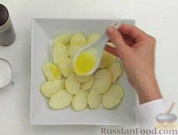 Картофельный салат с тунцом: Ломтики картофеля аккуратно выложить в салатник, полить оливковым маслом (0,5-1 ст. ложка). Посолить и поперчить.