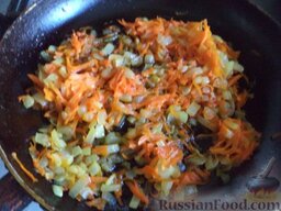 Рис с овощами: Разогреть сковороду, налить растительное масло. В горячее масло выложить лук и морковь. Тушить на среднем огне, помешивая, около 3-4 минут.
