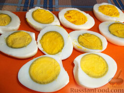Яйца, фаршированные икрой минтая и плавленым сыром: Очищенные яйца разрежьте вдоль пополам. Удалите из них желток, он будет служить начинкой.