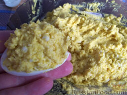 Яйца, фаршированные икрой минтая и плавленым сыром: Заполняйте половинки яичек начинкой и выкладывайте яйца, фаршированные икрой минтая, на тарелку.