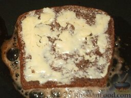 Ржаные гренки с чесноком и яйцом: Растопить на сковороде оставшееся масло, выложить хлеб на сковороду смазанной стороной вверх.