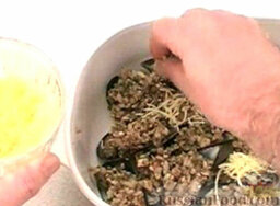 Мидии с грибами: В каждую раковину с мидией выложить немного грибного фарша.  Посыпать мидии с грибами тертым сыром.