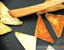 Кукурузная каша с гренками: Процеженное масло снова разогреть на сковороде.   Кусочки хлеба разрезать на треугольники, обжарить с двух сторон.