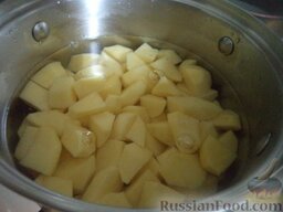 Капуста, тушенная с грудинкой и картофелем: Тем временем вскипятить чайник. Очистить и помыть картофель, нарезать кусочками, выложить в кастрюлю, залить кипятком. Варить на небольшом огне до мягкости (около 15-20 минут).