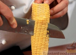 Эскитес - салат из кукурузы: Упираем початок вертикально в доску и ножом срезаем зерна.