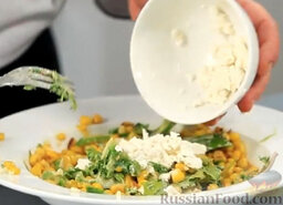 Эскитес - салат из кукурузы: Разминаем вилкой фету и добавляем в тарелку. Салат с кукурузой снова тщательно перемешиваем.