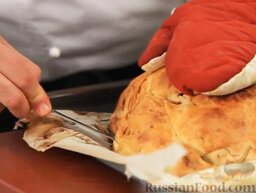 Фаршированная курица, запеченная в соленом тесте: Время удивлять ваших гостей. Вынимаем курицу, запеченную в тесте, из духовки. Маленьким ножиком надрезаем тесто вдоль нижнего края, не до конца.