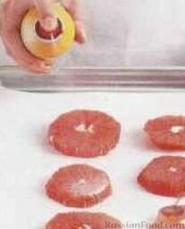 Морские гребешки и грейпфрут, жаренные на гриле: Нарезать очищенный грейпфрут кружочками, выложить на застеленный пергаментом противень и сбрызнуть растительным маслом.