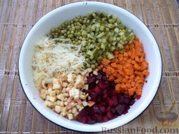 Праздничный винегрет: Сложите все ингредиенты в одну большую тару, добавьте консервированный зеленый горошек и квашеную капусту.