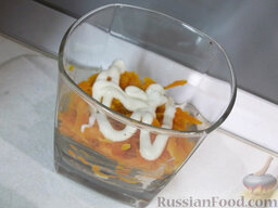 Салат "Мимоза" в стакане: Сверху выложите маринованный лук с морковью и снова полейте майонезом.