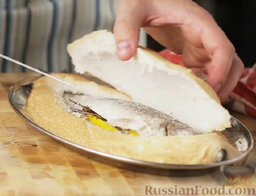 Сибас, запеченный в "панцире" из соли: Достать рыбу из духовки. Разрезать и снять соляной 