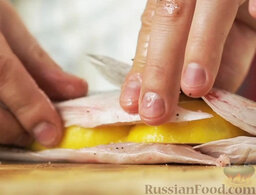 Сибас, запеченный в "панцире" из соли: Лимон разрезать на крупные дольки. Вложить их в рыбу.