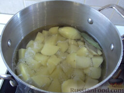 Картофельные зразы с мясом: Налейте воду, добавьте лавровый лист и поставьте вариться. Примерно через 20 минут проткните картофель вилкой - если он будет мягкий, то снимайте с плиты.