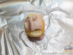 Картофель, запеченный на углях: Сверху выложите чеснок, сало и прикройте второй половинкой картофеля.
