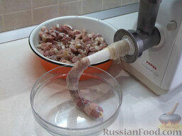 Домашняя колбаса: На мясорубку установите насадку для колбас, наденьте на нее оболочку и сделайте узелок.   Запустите прибор, закладывайте фарш в мясорубку и наполните им всю оболочку.