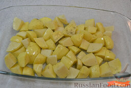 Запеченная курица с картошкой: Включить духовку (разогреть до 220 градусов).  Картофель очистить, нарезать небольшими кусочками. Выложить картофель в жаропрочную форму. Посолить и поперчить, перемешать. Добавить оливковое масло, перемешать.
