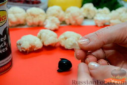 Украшение блюда "Овечка из капусты": Взять маленькое соцветие капусты и вставить его в круглое отверстие оливки.