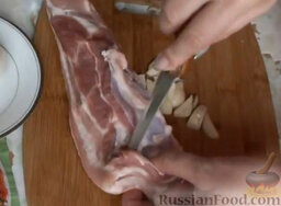 Свинина с картошкой в духовке: Нашпиговать подчеревок чесноком. Для этого острым ножом сделать глубокие вертикальные прорези.