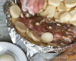 Свинина с картошкой в духовке: Картошку сверху посолить (1 ч. л. или по вкусу) и посыпать приправой для картофеля. Добавить лавровый лист. Влить стакан воды.