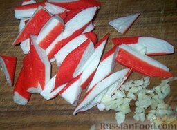 Салат из краснокочанной капусты с крабовыми палочками: Крабовые палочки нарезать кусочками. Чеснок очистить и мелко порубить ножом.