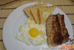 Яйца в облаках: Вынуть яйца из духовки. Выложить на блюдо яйца, бекон и ломтики тостов. «Яйца в облаках» можно подавать.  Приятного аппетита и хорошего настроения на весь день!
