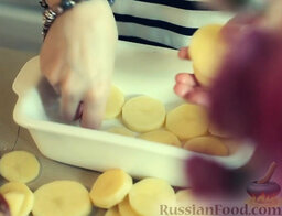 Картофельный гратен в сливочном соусе: Форму для запекания смазать растительным маслом. Аккуратно выложить кружочки картофеля в один слой (половину всего картофеля).