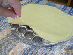 Сибирские пельмени: Пельменницу посыпьте мукой и положите  сверху раскатанное тесто.