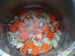Диетические рыбные котлеты: Очистить и помыть одну луковицу и морковь. Нарезать кольцами. Выложить на дно кастрюли. Налить 0,5 стакана холодной воды.