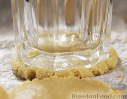 Имбирное печенье: Придавить каждый шарик стаканом, формируя лепешку.