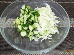 Салат с сырыми шампиньонами: Огурцы помойте, порежьте полукольцами и добавьте в салатницу к капусте.